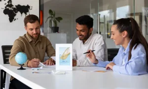 Three friendly study abroad consultants in Kerala discussing international education plans with students at a modern office table.